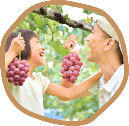 男性と女の子が笑いあってブドウを持っている